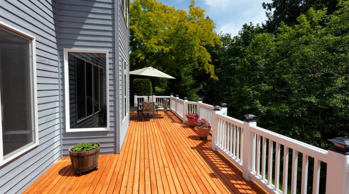 a long upper deck of a house, wood flooring and railings painted for protection